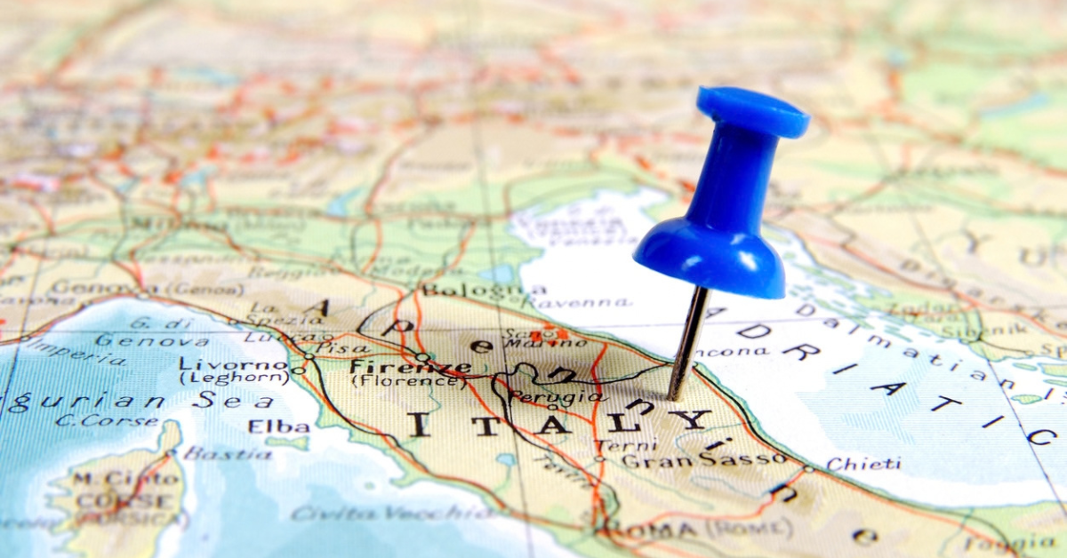Blue pushpin marking central Italy on a map