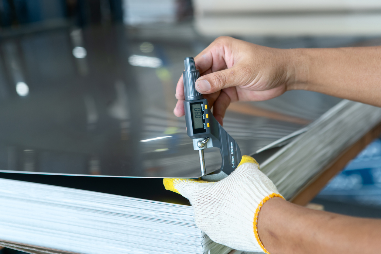 hand measuring metal thickness